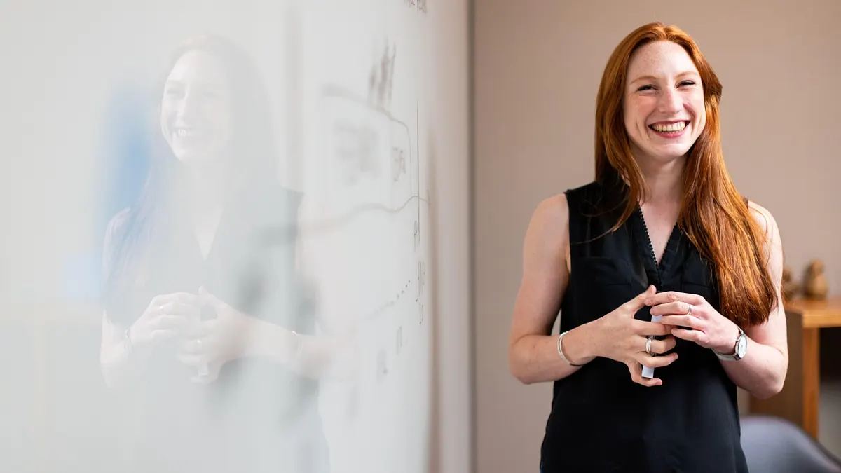 Femme travaillant dans un bureau devant un tableau blanc