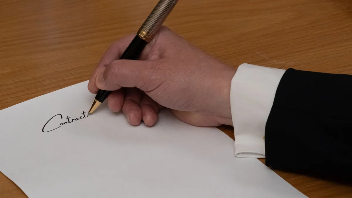 Signature d'un contrat commercial avec un stylo élégant.